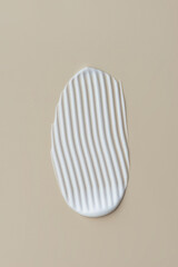 Smears of white cream on a beige background, cream texture