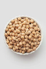 Chickpeas in a white plate on a white background. View from above.