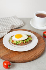 Toast with guacamole and avocado in a white plate on the table