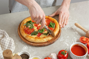 The process of making margarita pizza. Male hands, top view. Tomato paste with cheese.