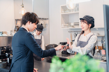 カフェでクレジット決済をするビジネスマン