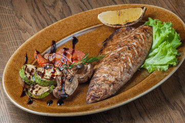 Baked mackerel on a lettuce leaf with baked mushrooms, tomatoes and zucchini
