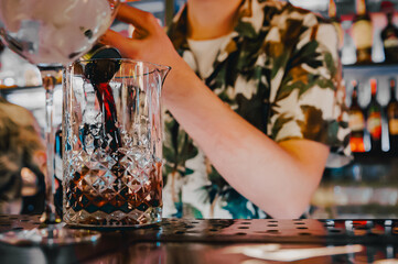 man bartender hand making negroni cocktail