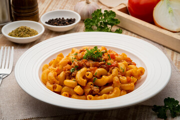 Stir fried macaroni with tomatoes sauce and mince pork on white plate