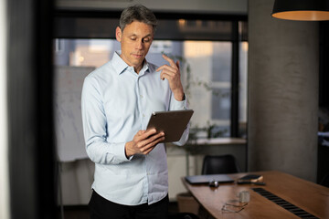 Fototapeta na wymiar Portrait of businessman in office. Man using digital tablet. Businessman having video call