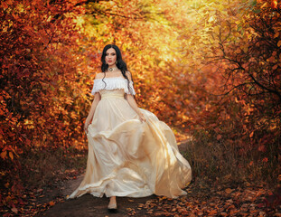 Obraz na płótnie Canvas Art photo fantasy woman queen walking in gothic autumn forest, white vintage style dress. Girl princess beauty face long wavy hair, elegant sexy bare open shoulders. Red orange yellow color dark tree.