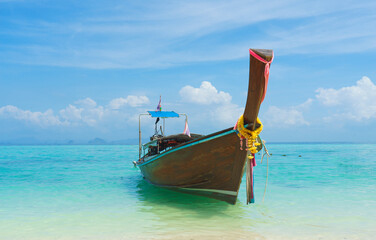 Thai traditional wooden longtail boat and beautiful sand beach in Thailand. Traveling concept.