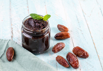 Date paste, a healthy sweet in a steeple jar, wooden background.