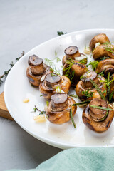 Roasted mushrooms champignons with garlic and herbsvertical photo.