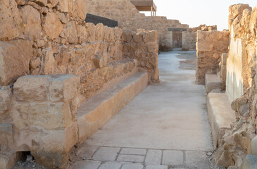 The remains  of internal buildings in the rays of the rising sun in the ruins of the fortress of Masada - is a fortress built by Herod the Great on a cliff-top off the coast of the Dead Sea, Israel