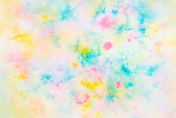 Blue, green, pink and yellow watercolor paint on paper background.