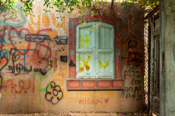 Old house with painted walls on exhibition in the Gardens Almona collection, in the rays of the setting sun, in the Druze village of Julis in northern Israel