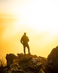 A man standing on a stone at sunrise on Jested in the Czech Republic.