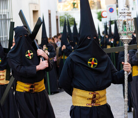 Penitents or Nazarenes carrying crosses during a Holy Week procession.