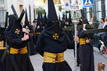 Penitents or Nazarenes carrying crosses during a Holy Week procession.