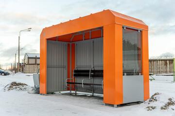 an empty orange bus stop in winter