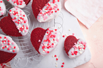 Obraz na płótnie Canvas Red velvet or brownie cookies on heart shaped in chocolate icing on a pink romantic background. Dessert idea for Valentines Day, Mothers or Womens Day. Tasty homemade dessert. Cake for Valentines Day