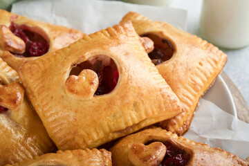 Valentines day heart shaped Hand pies. Mini puff pastry or hand pies stuffed with apple and sprinkle sugar powder in plate. Idea for homemade romantic snack Valentines day. Top view. Copy space.