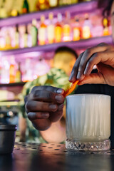 man hand bartender making white cocktail in glass on the bar counter