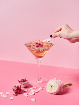 Crop person decorating mocktail with petal