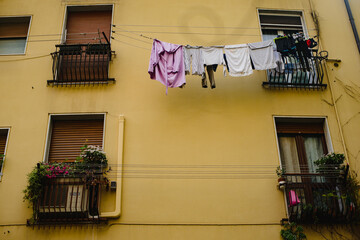 Linen, clothes are dried on a rope, hanging on the facade of the building between the windows. Old Europe
