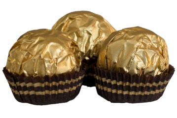 one chocolate candy on a neutral gray white background a lot of chocolates in golden packaging lies on the background candy in hands