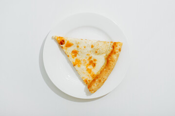 Top view a slice of cheese pizza with on a white plate on the table