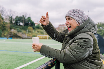 Joyful senior woman with takeaway coffee