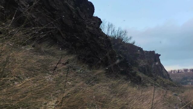 Winter landscape. Rock formation is snowing. Nature footage in slow motion.