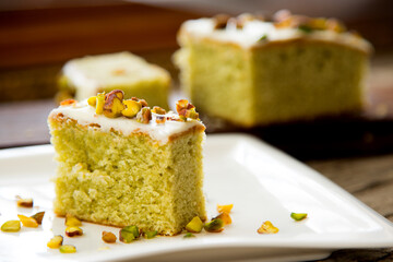 Pistachio sponge cake covered in icing sugar.