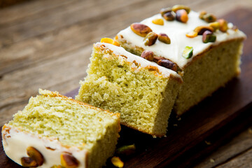 Pistachio sponge cake covered in icing sugar.