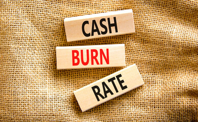 Cash burn rate symbol. Concept words Cash burn rate on wooden blocks on a beautiful canvas table canvas background. Business cash burn rate concept. Copy space.