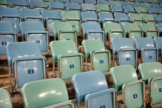 Numbering of empty seats in the stadium arena for spectators and fans. Backrest of free plastic seats in the stadium with raised seats
