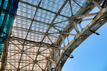 Fototapeta premium Modern steel structure of the stadium roof. In the indoor arena of the stadium there are bright LED lights on the roof on a metal structure. 