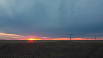 Large windmills against the backdrop of a red sunset