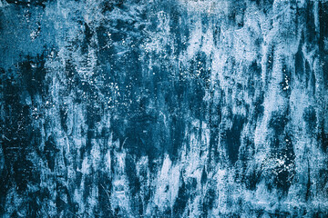 Stains of luminous paint on a dark blue wall background.