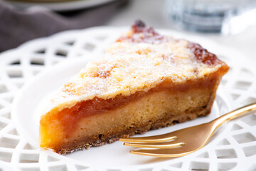 明るいテーブルにりんごタルトと金色のフォーク