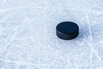 black hockey puck lies on ice at stadium