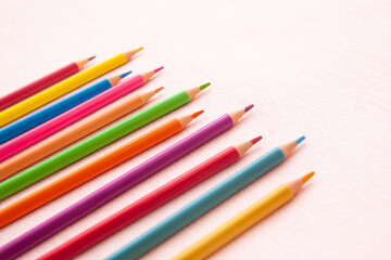 Colorful pencils on pink background, back to school and art education card
