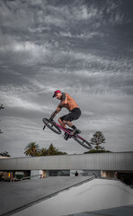 Bmx rider in the skatepark jumping with the bike. Boy with tattoos. Urban photography