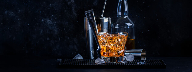 Godfather alcoholic cocktail with scotch whiskey, amaretto liqueur and ice. Black bar counter...