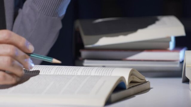 Close-up Researcher, historian, mature old man doing historical research reading a book.
A historian who reads, translates and writes scientific books.
