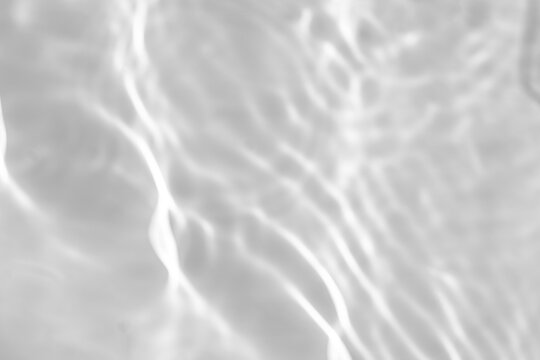 Blurred defocused water texture overlay effect for photo and mockups. Organic drop diagonal shadow and light caustic effect on a white wall. Shadows for natural light effects