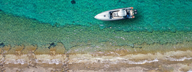 Aerial drone ultra wide top down photo with copy space of inflatable speed boat anchored in tropical exotic island
