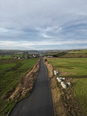 Aerial view of a country road surrounded by farmland and fields. Taken in Bury Lancashire England. 