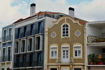 Tiled facades of colourful buildings with windows and balconies outside on the river channel in Aveiro, Portugal. Portuguese architecture