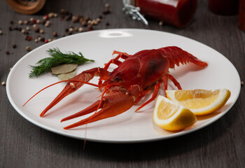 Large boiled crawfish on a plate with lemon and pepper