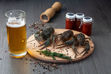 Fresh crawfish on the cutting board with beer and souce on a wooden table