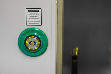 Door of train carriage or subway car with the electric green button press to open doors between the...