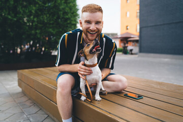 Cheerful male hugging dog in park